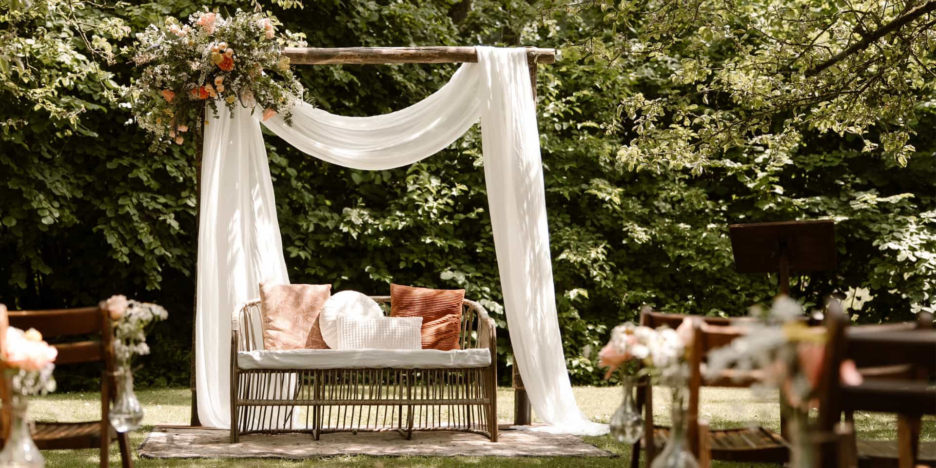 Ceremoniestyling met houten stoelen en een backdrop op het trouweiland bij Dengh